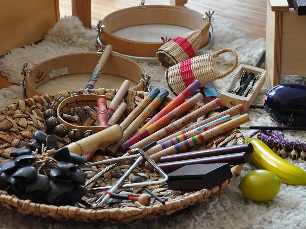 Ansammlung von Gegenständen und Musikinstrumenten in einer Schale auf einem Teppich