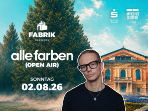 DJ Alle Farben mit Brille und Kette vor einem großen Baum und dem historischen Festspielhaus
